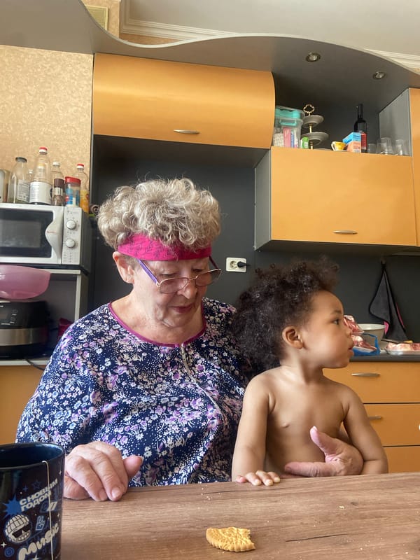 Grandmother holds toddler in Kazan kitchen Friday morning