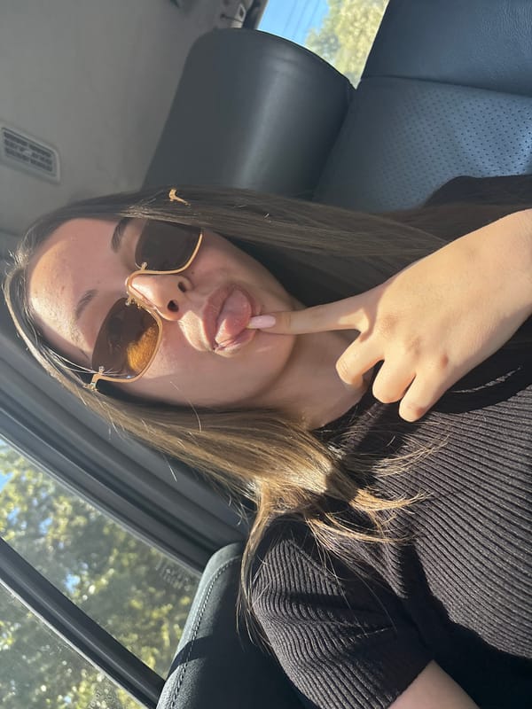 Woman poses playfully in car with decorative manicure in Burgas