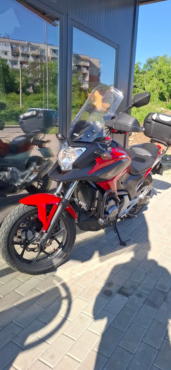 Red Honda motorcycle spotted parked outdoors on sunny day
