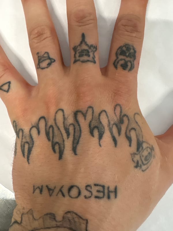 Tattooed hand and wrapped orange sauce portions on a table