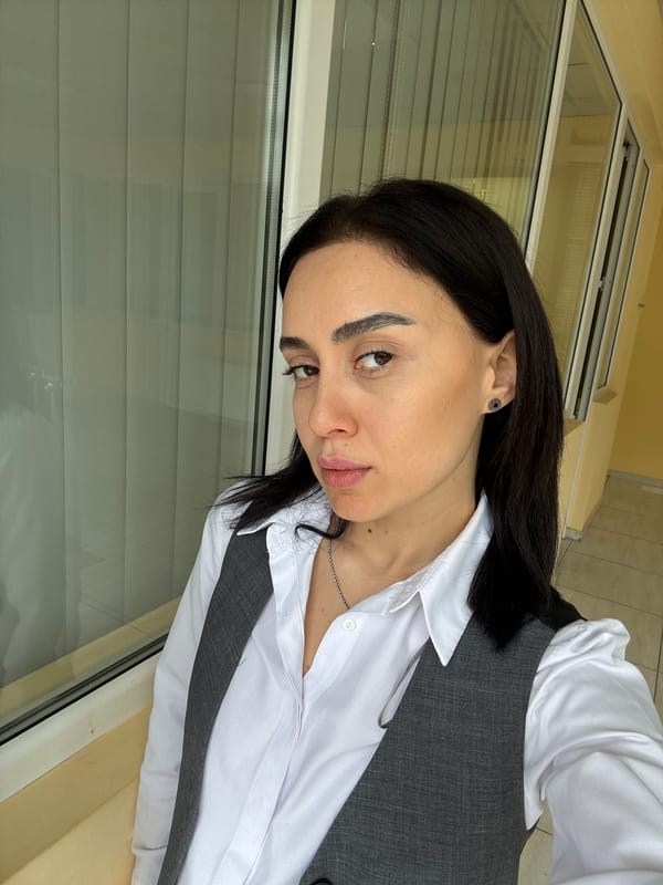 Woman photographed in business attire near window in Tbilisi
