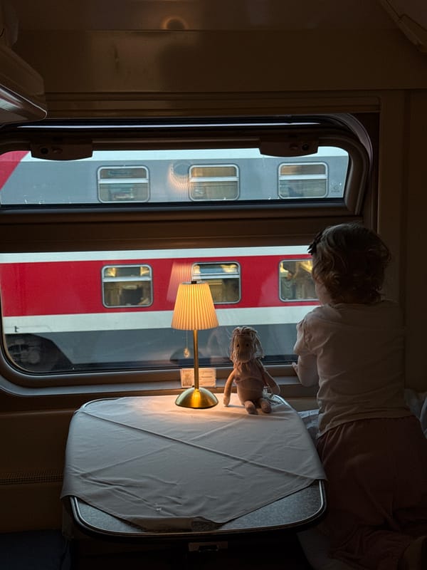 Child watches from train window in Moscow with doll