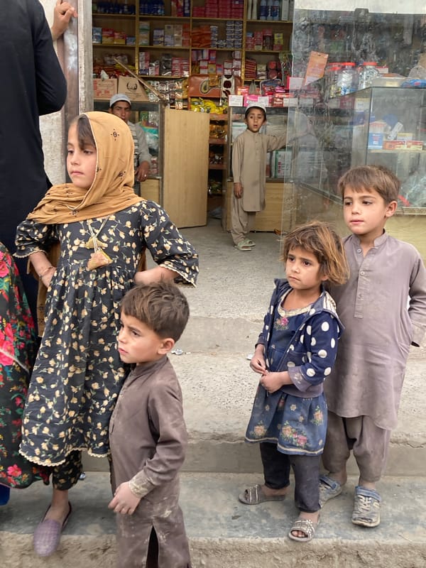 Children gather near storefront in Qilla Saifullah, Pakistan