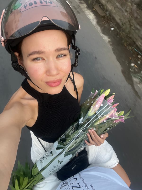 Woman rides scooter carrying flower bouquet in Nha Trang