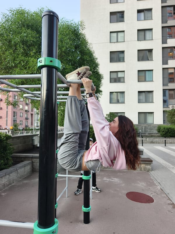 Woman exercises on monkey bars at Tyumen playground