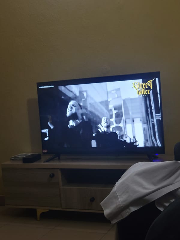 Black and white 'Street Killer' music video plays on a TV screen
