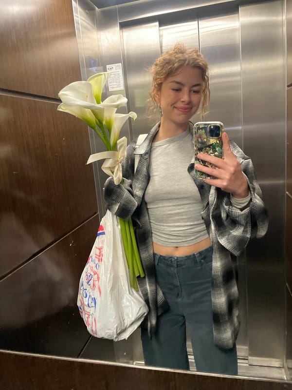 Woman takes elevator selfie with white calla lilies in Montenegro