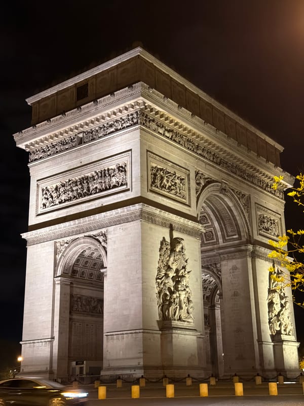 Arc de Triomphe illuminated against dark Paris night sky