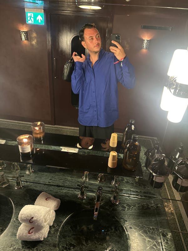 Mirror selfie in a candlelit London bathroom, blue shirt and skirt