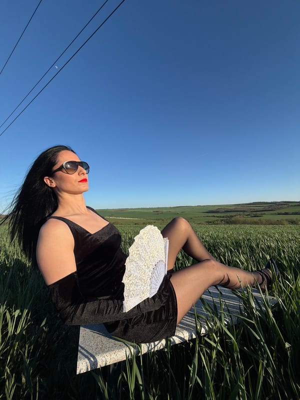 Woman relaxes with fan in Pleven grassland
