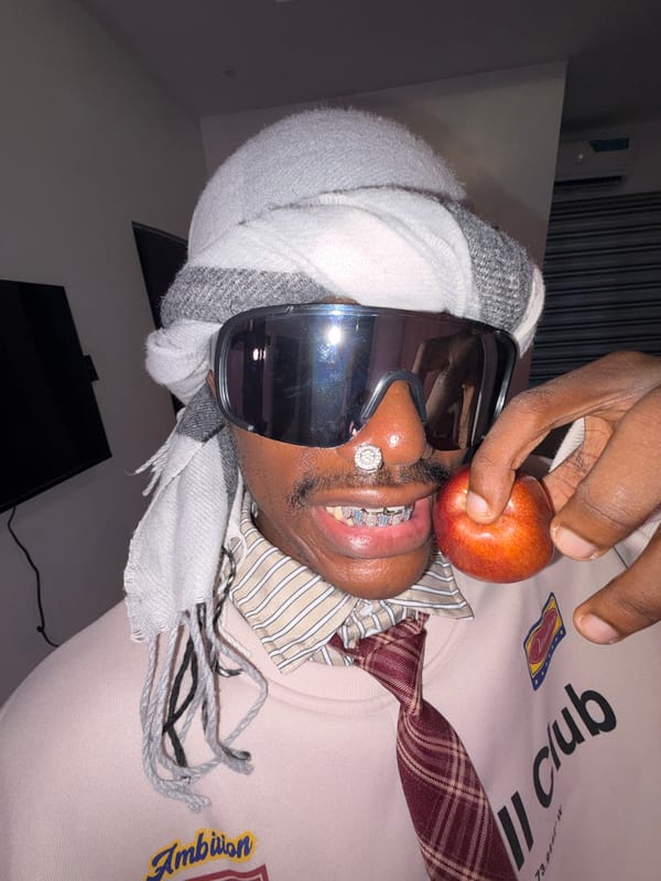 Man with diamond jewelry holds apple in Igboefon