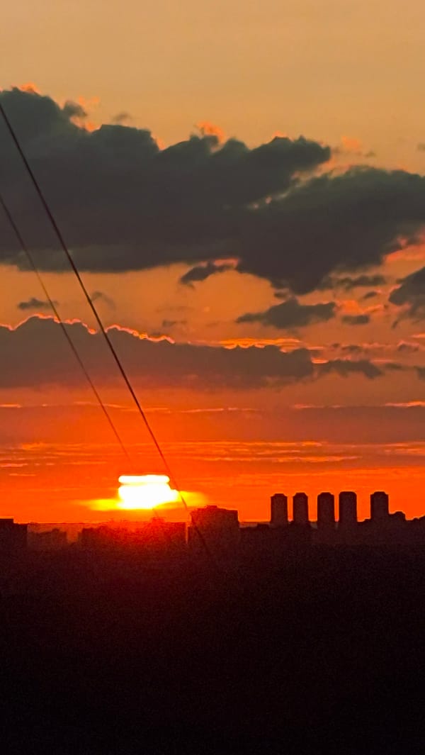 Two-angle sunset over an unidentified city skyline