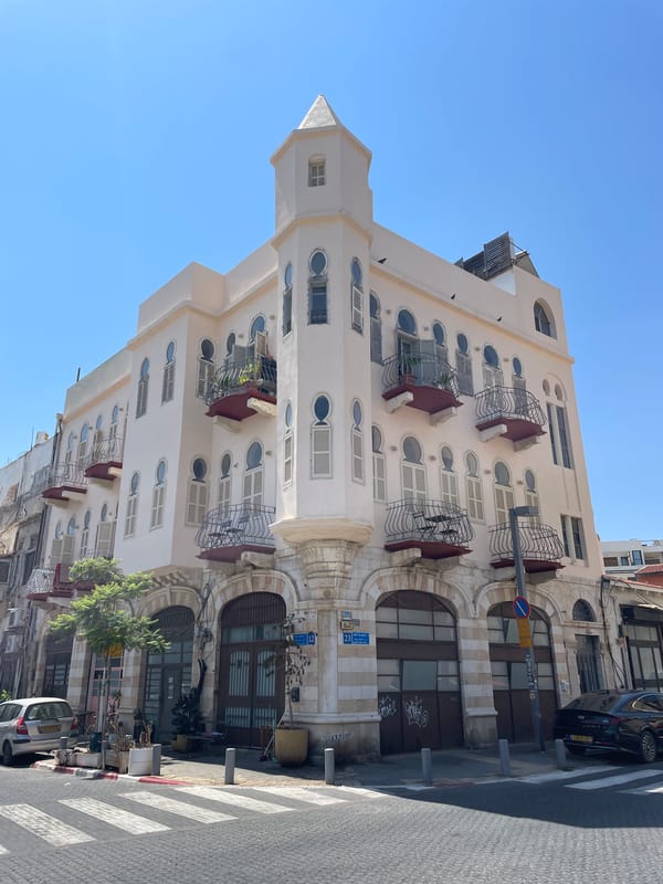 Ornate corner building and passing tram in central Tel Aviv