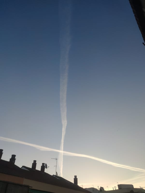 Aircraft contrails form X pattern over Barcelona morning sky