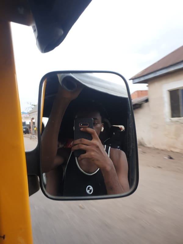 Tricycle passenger documents mirror selfies through Lokoja market streets