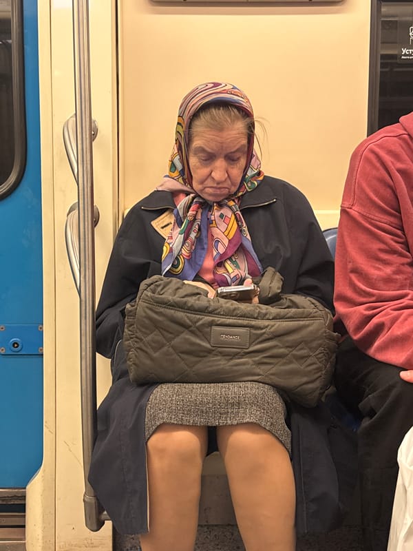 Elderly woman sleeps on Moscow train with colorful headscarf