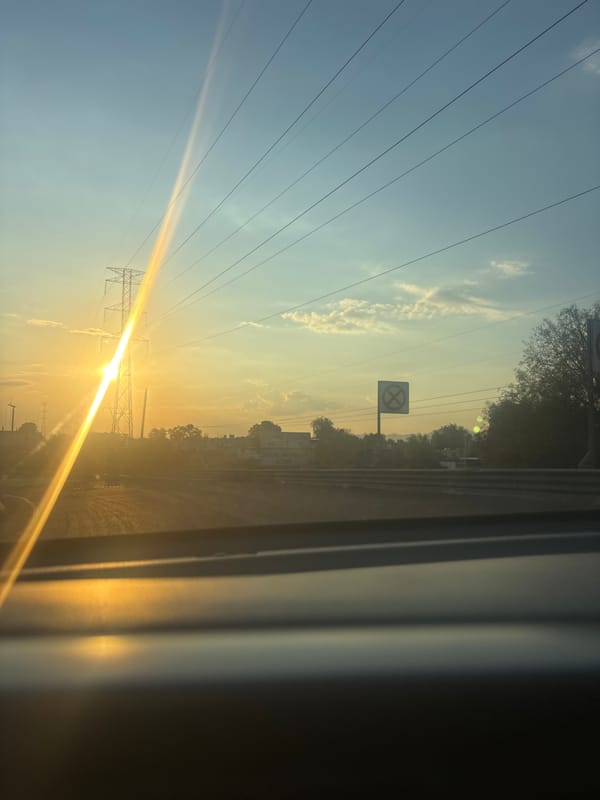 Vehicle view of railroad crossing at sunrise in Tultitlán