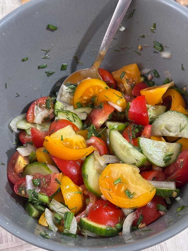 Chopped tomato and cucumber salad in a grey bowl
