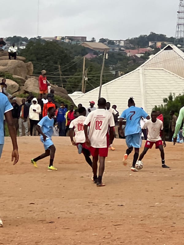Pickup soccer on a rocky dirt pitch in Jos, Nigeria