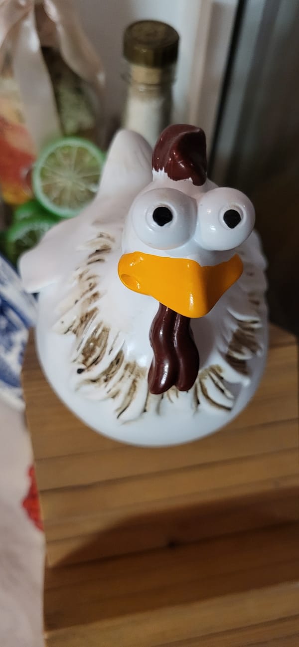 Quirky ceramic chicken figurine on a wooden surface, Almaty