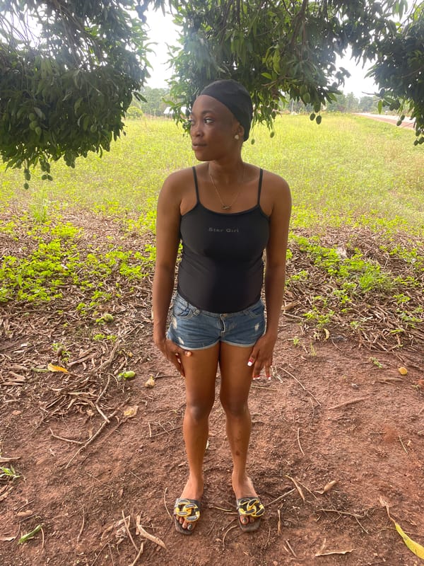 Woman in 'Star Girl' tank top observed outdoors in Ogpe, Nigeria