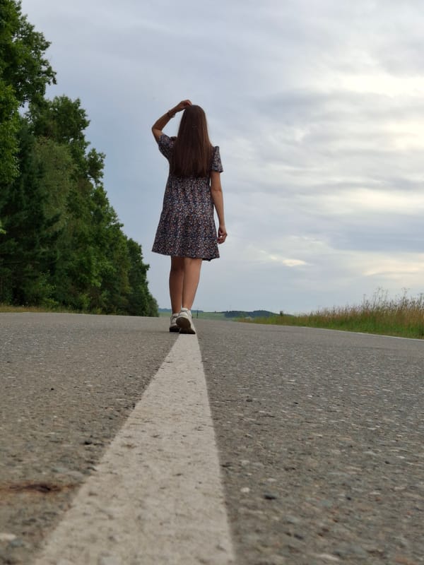 Daisies and a floral dress on a quiet rural road