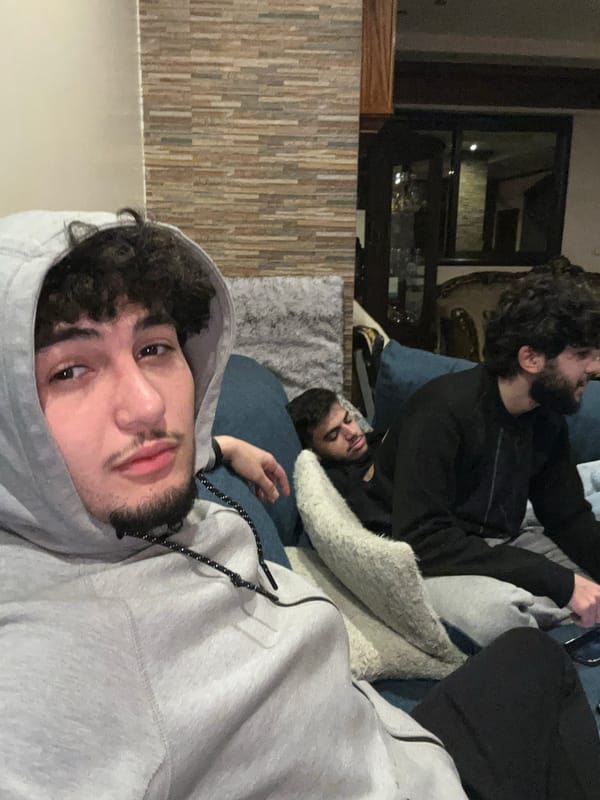 Young men spend casual evening with phones, cat in Syria