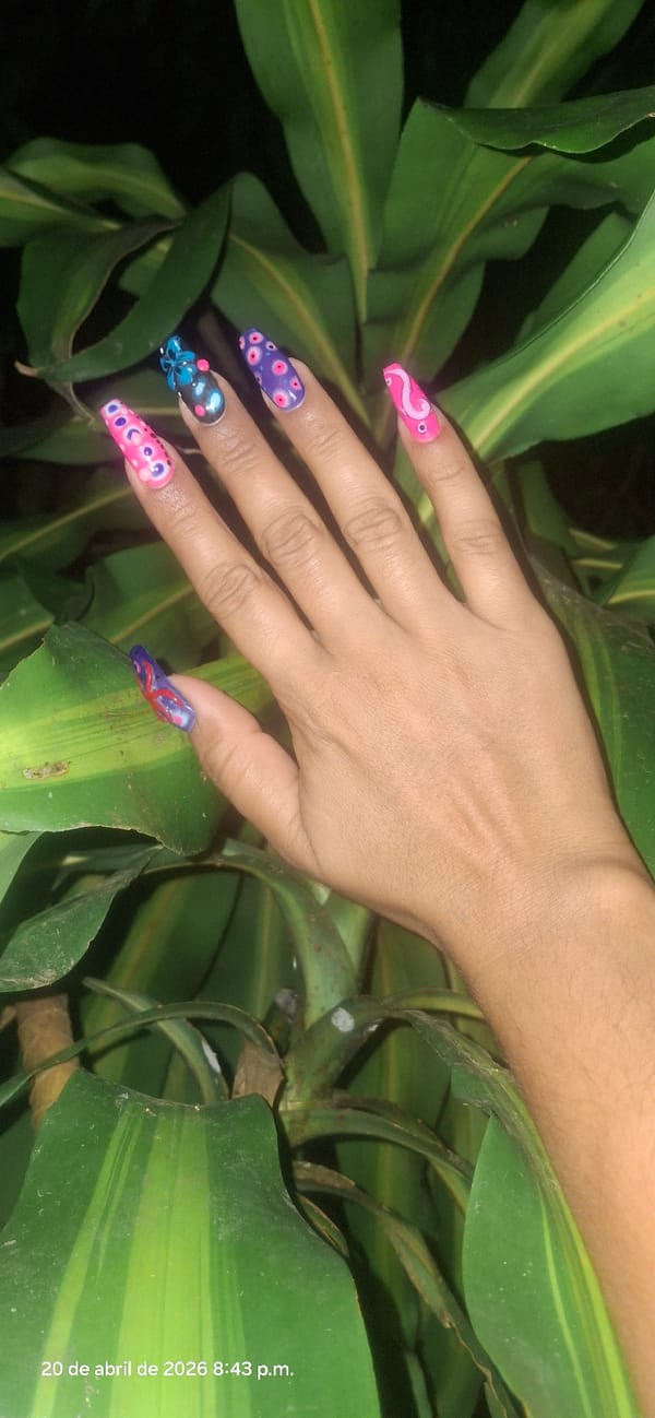 Person with decorated nails, planetary tattoo photographed in Venezuelan garden