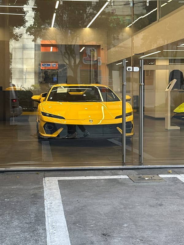 Yellow Lamborghini displayed behind glass window in Mexico City