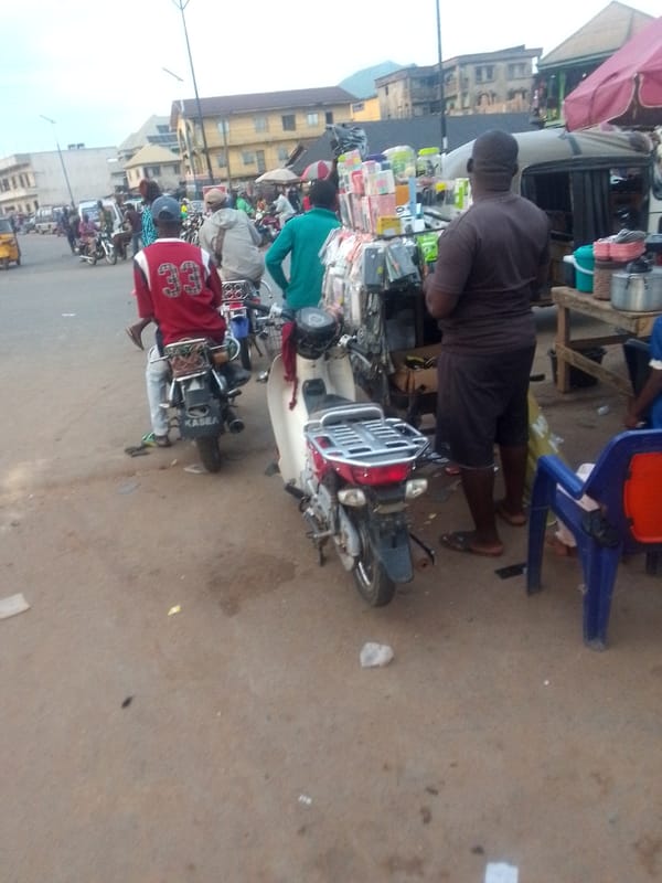 Urban marketplace scene with van, motorcycles, pedestrians captured