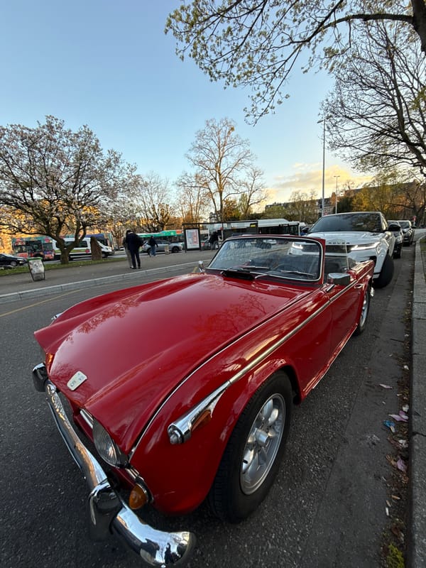 Man tours Strasbourg landmarks with vintage red Triumph convertible