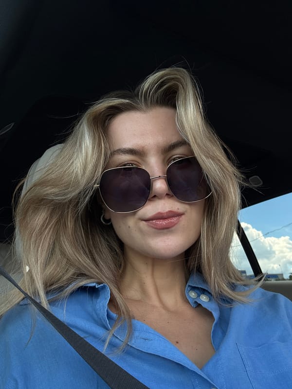 Woman in blue shirt documented during scenic road trip