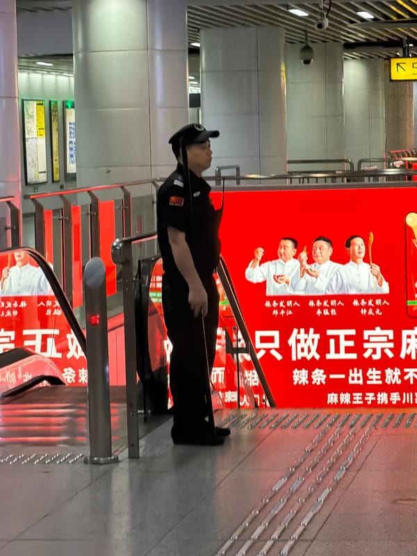 Street scene outside a bold red food advertisement in Yuzhong District
