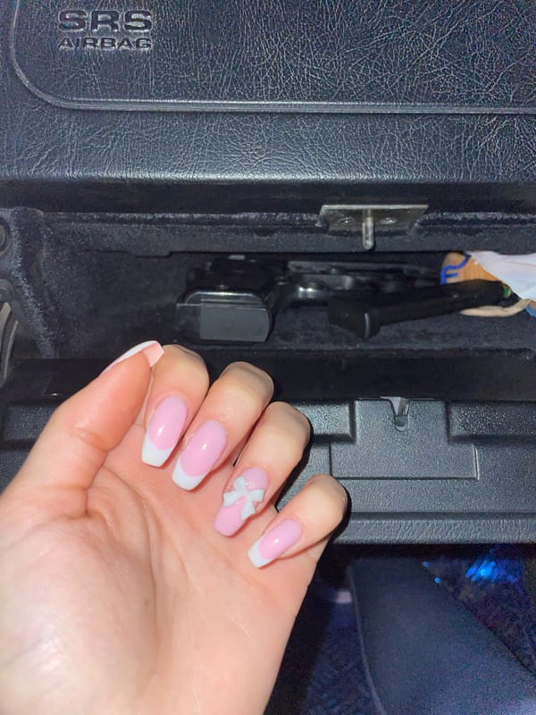 Manicured hand with decorative nails photographed in car interior