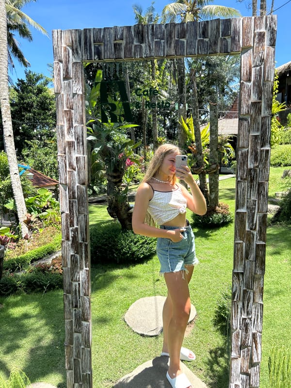 Woman takes mirror selfies at tropical garden in Gianyar