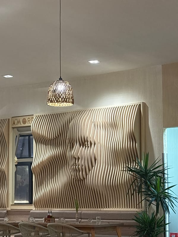 Beachside restaurant with wooden slat face sculptures and coastal decor