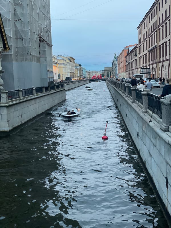 Canal boats, domed buildings, and tourist carriages in a European city