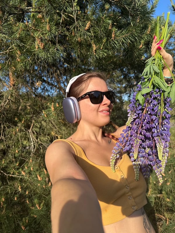 Woman poses with purple lupines in Vladimir park