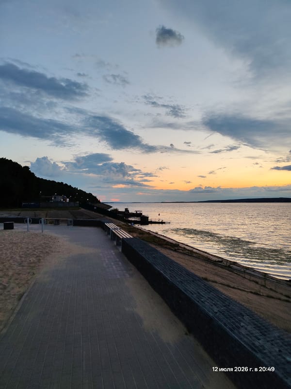 Waterfront promenade at dusk, people walking and cycling