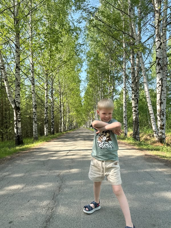Children play on birch-lined road in Банное, Russia