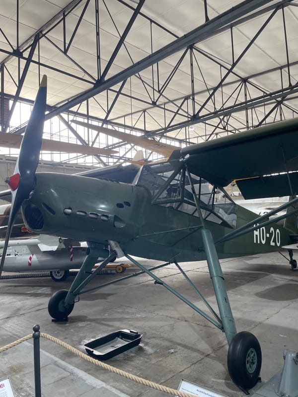 Vintage aircraft and a classic Tatra on display indoors