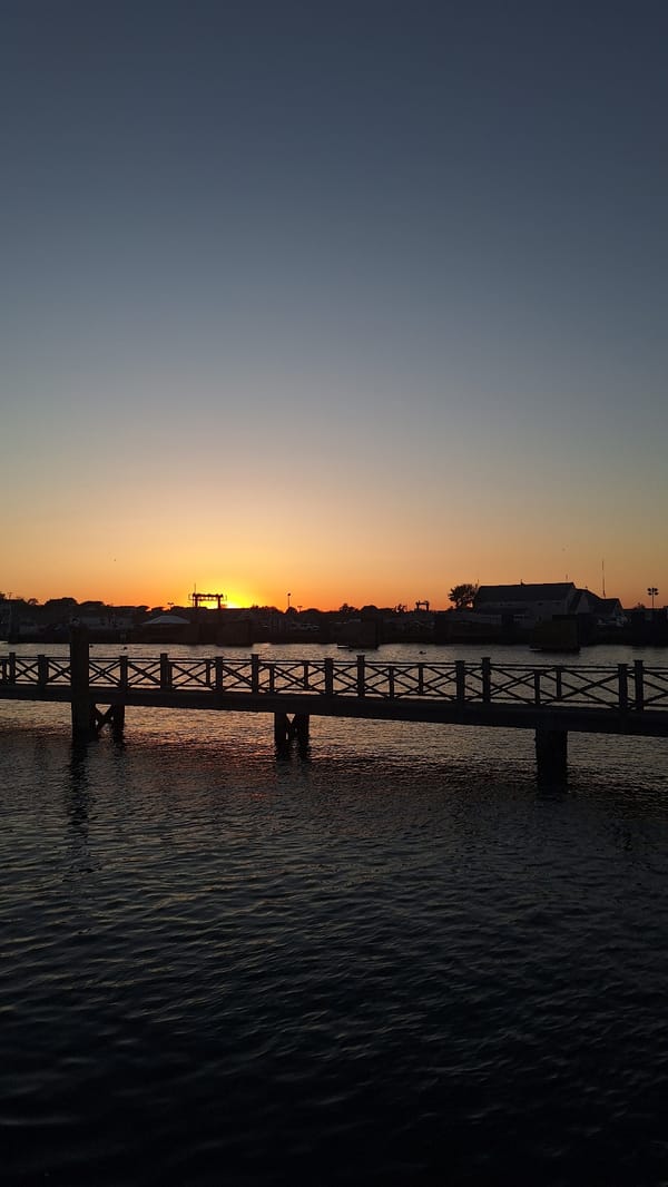 Sunset views across Nantucket harbor with pier and boats
