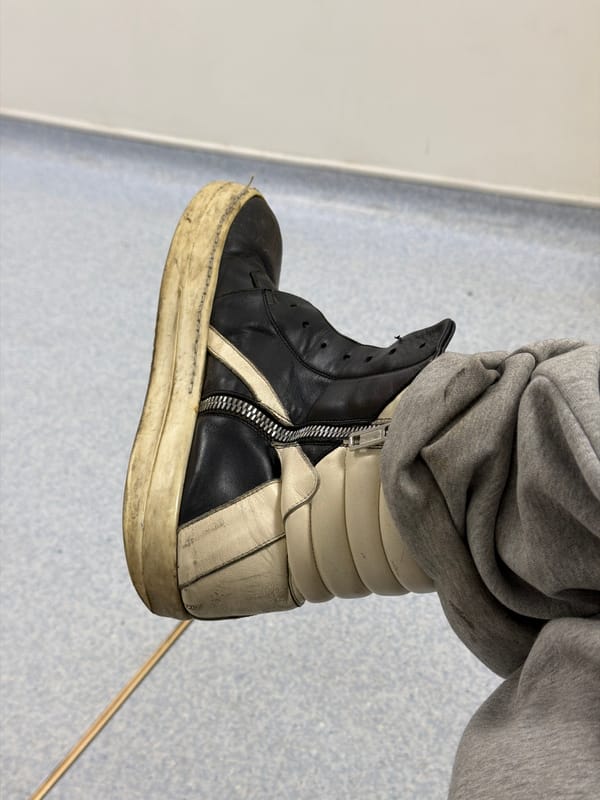Person in worn sneakers observed standing indoors in London