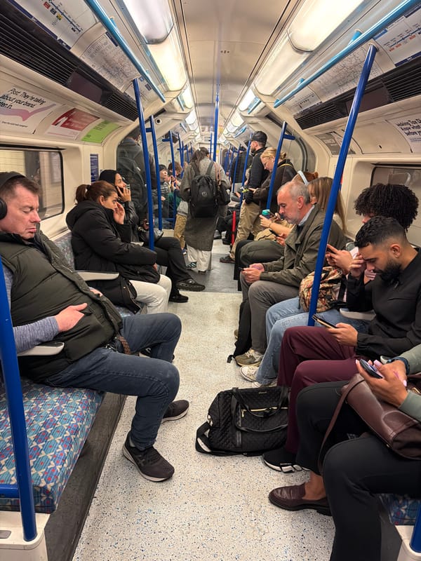 Crowded London tube passengers scroll phones during morning commute