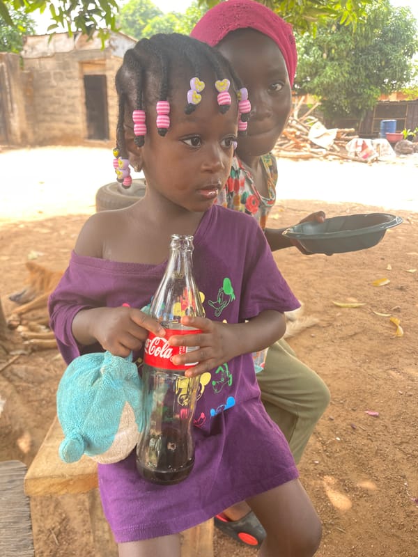 Child enjoys Coca-Cola in rural Nigerian town