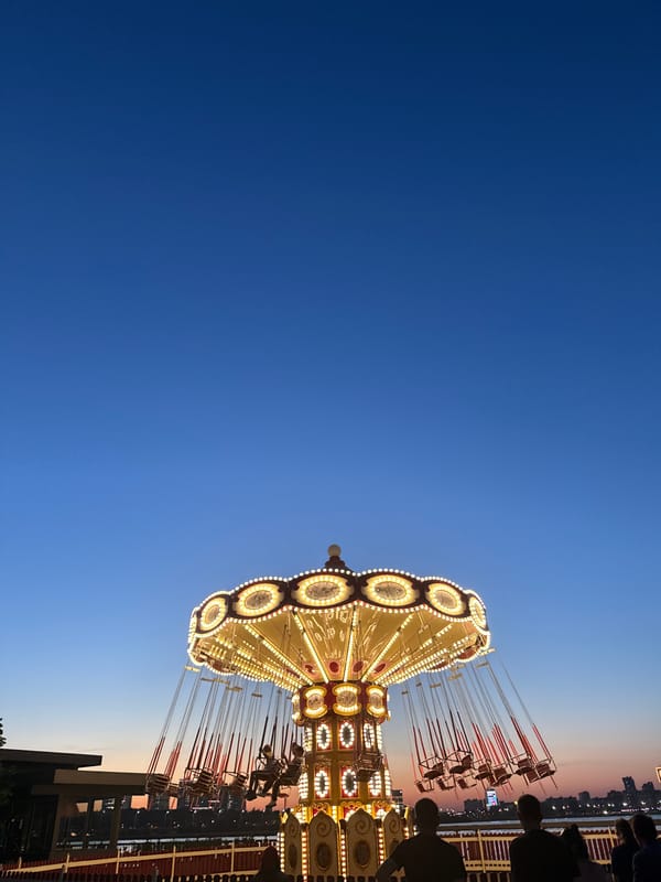 Lit carousel photographed against evening sky in Kazan