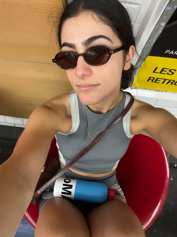 Woman waits in metro station chair with water bottle