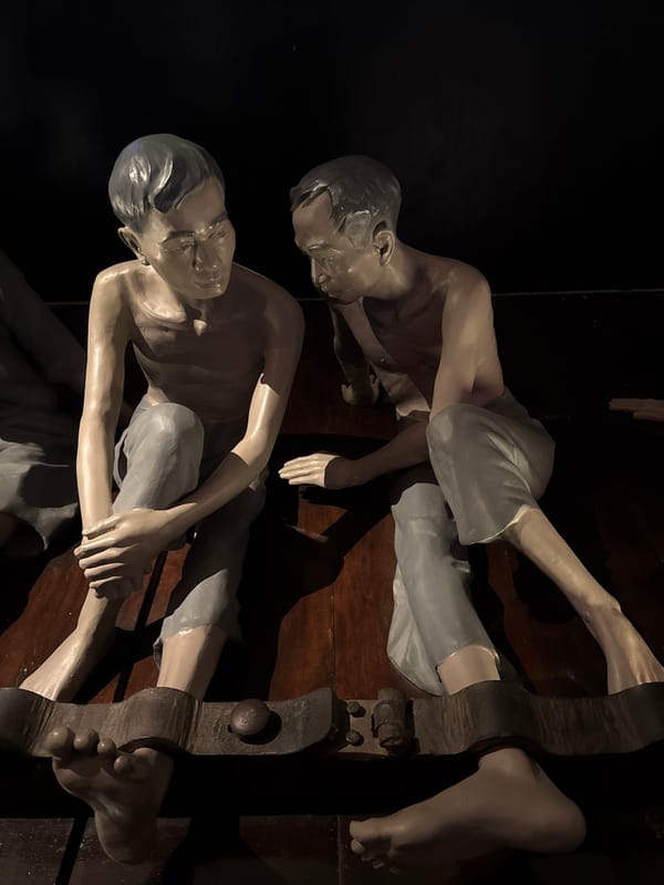 Tourists document historical prison museum exhibits in Hanoi