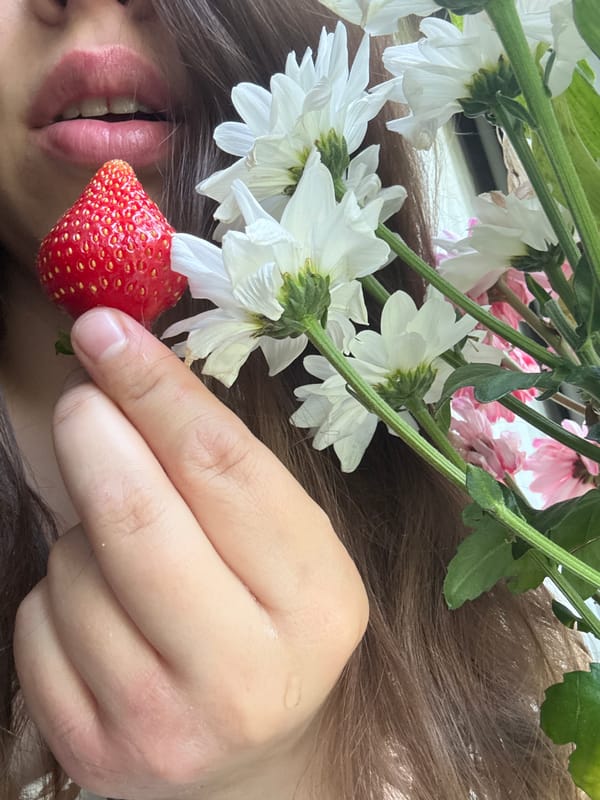 Person enjoys fresh strawberries and flowers in Krasnoyarsk morning
