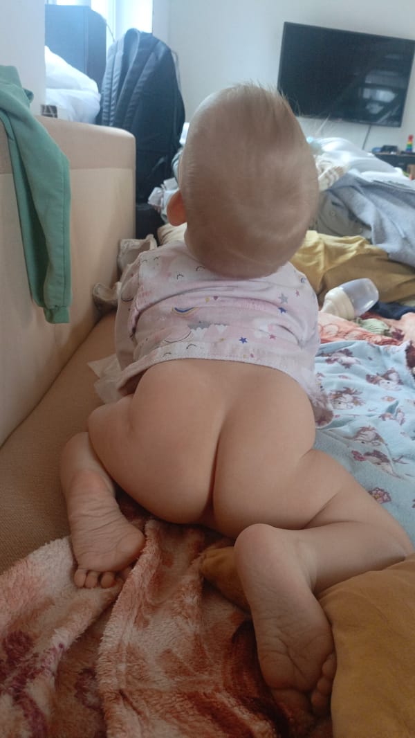 Baby in unicorn shirt sits on sofa in Sarapul